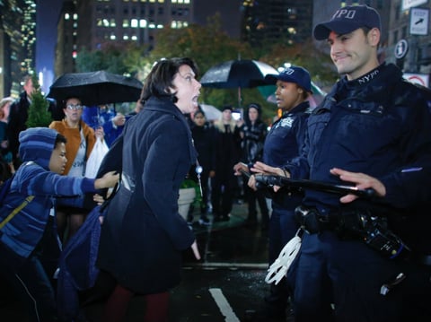 A woman argues with NYPD officers as she takes part in a protest against President-elect Donald Trump in New York City tonight.
